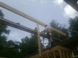 Carpenter setting a ridge beam over a new addition frame — Ice Dam Removal by Roofing Brothers in Rosendale