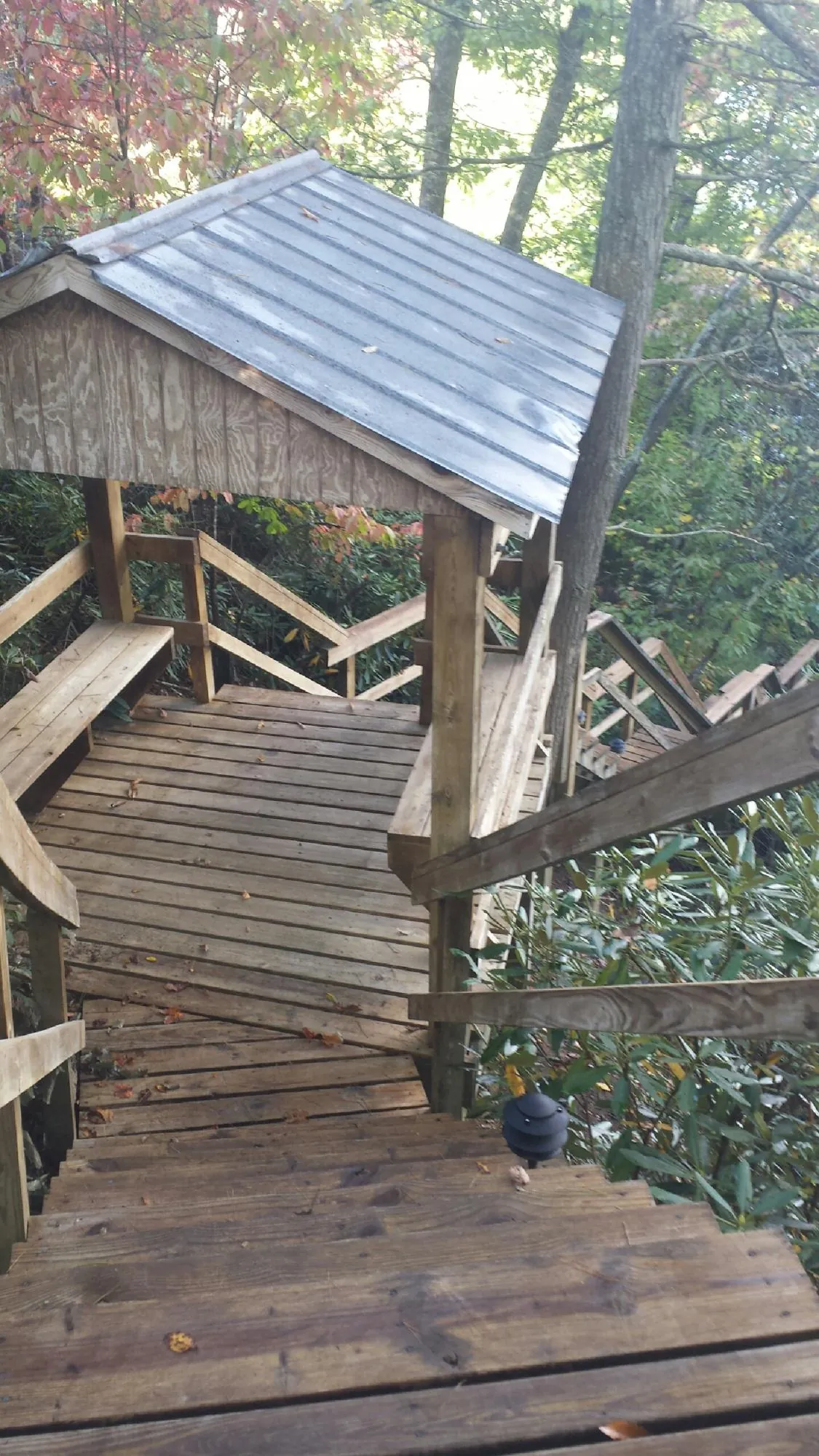 Metal roofed shelter over wooden steps on a wooded walkway — Skylight Repair & Installation work by our crew in Rosendale